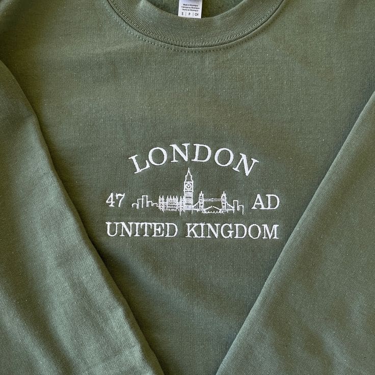 Schriftzug London 47 AD United Kingdom mit Big-Ben-Skyline, gestickt auf olivgrünem Sweatshirt